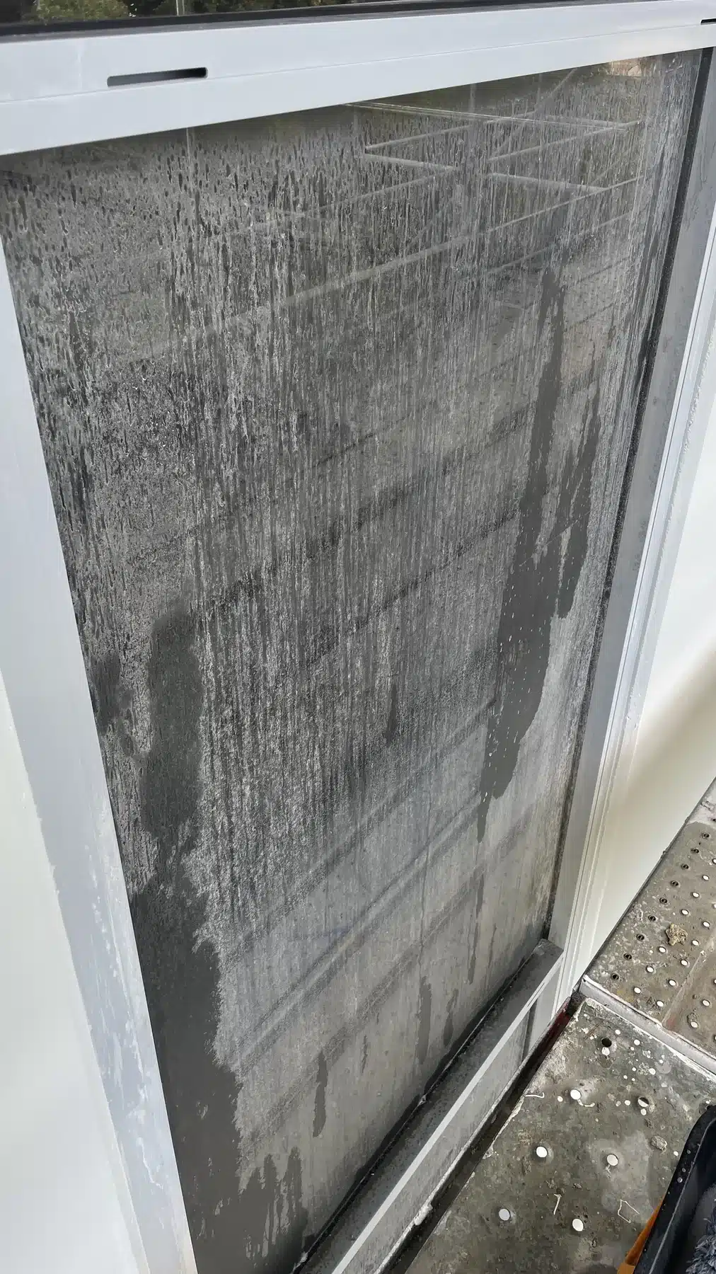 Before photo of construction residue on glass before a Gold Coast builders window clean